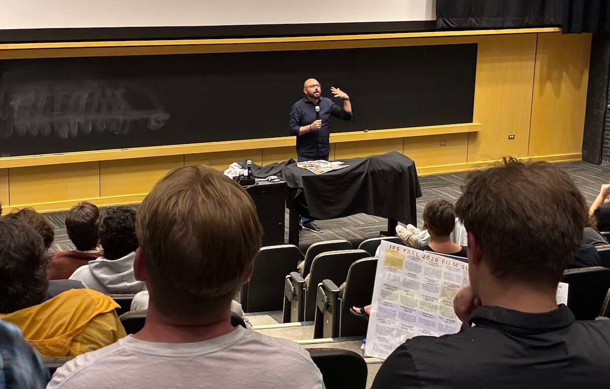 Jason Phelps, director of the International Film Series program, speaks before a crowd in Muenzinger Auditorium