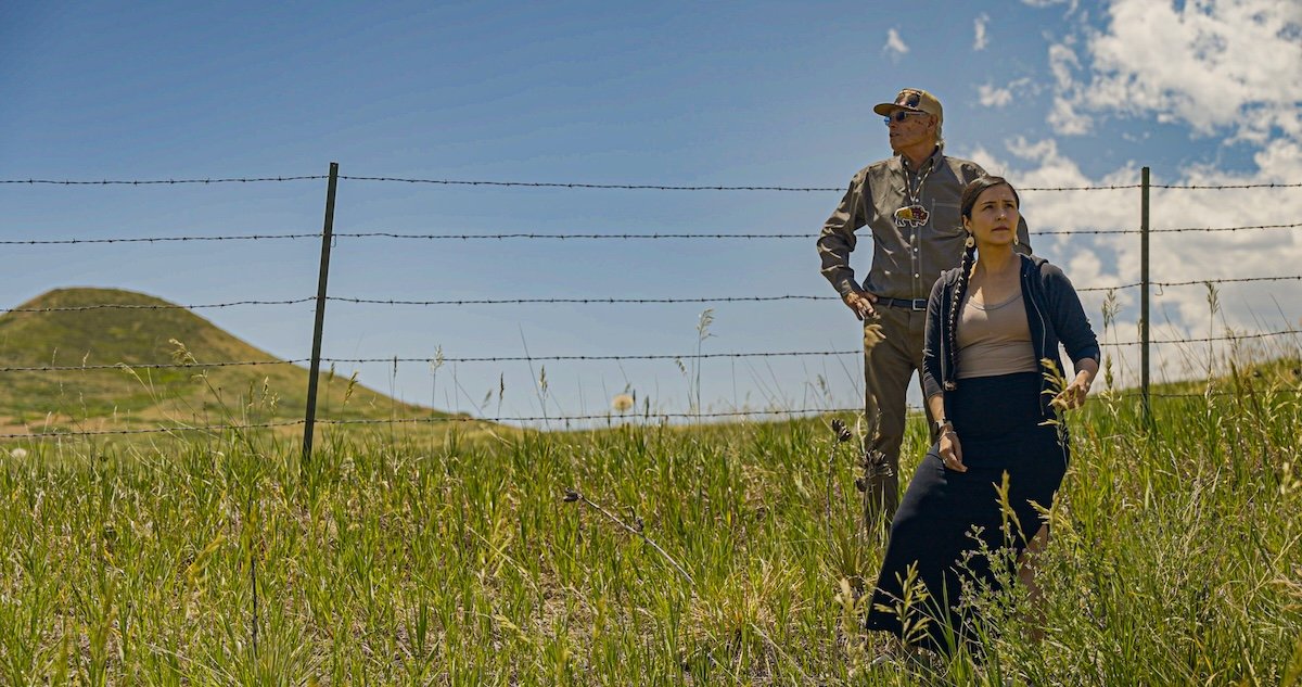 Two people stand by a fence