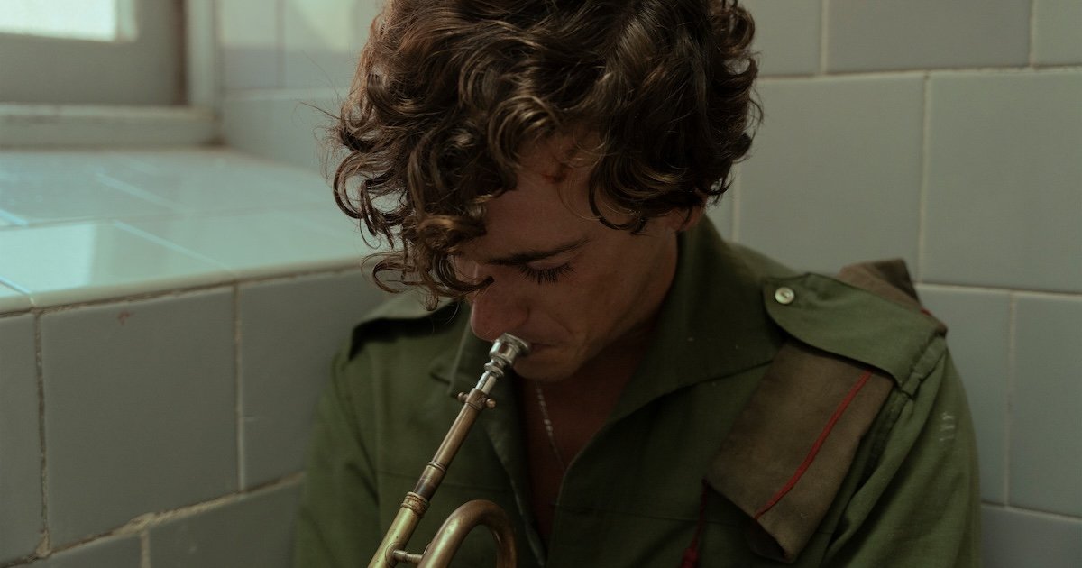 A man plays the trumpet in a scene from La Bola Negra