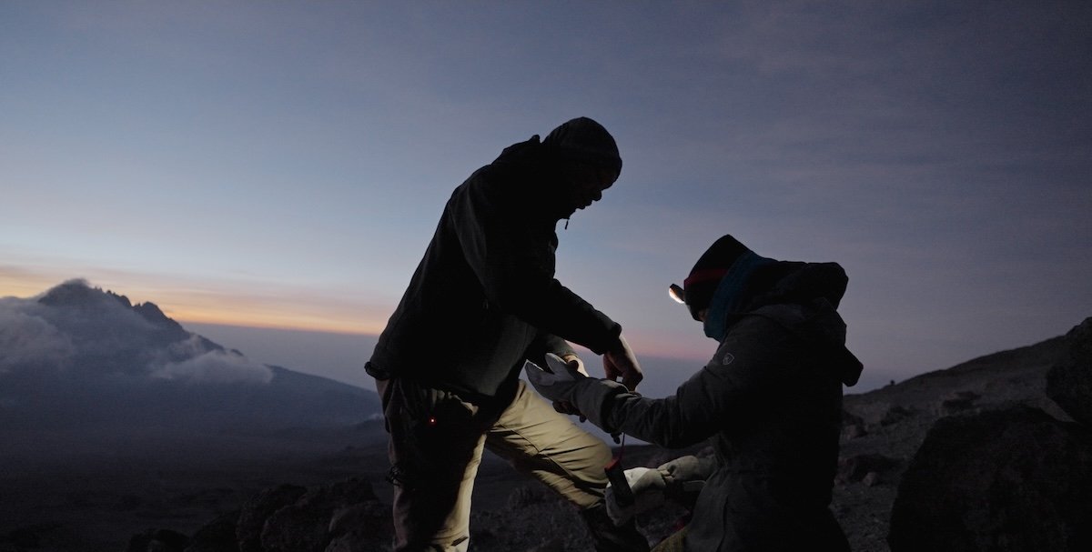 Two subjects from the "The Ascent" work together on a mountain