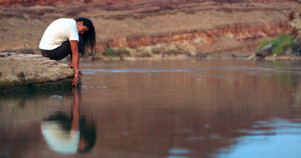 A person touches water during a scene from "The River"